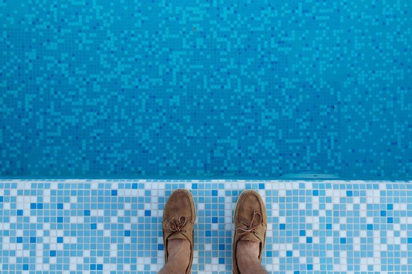 How do UK pool regulations impact the design and placement of diving platforms?